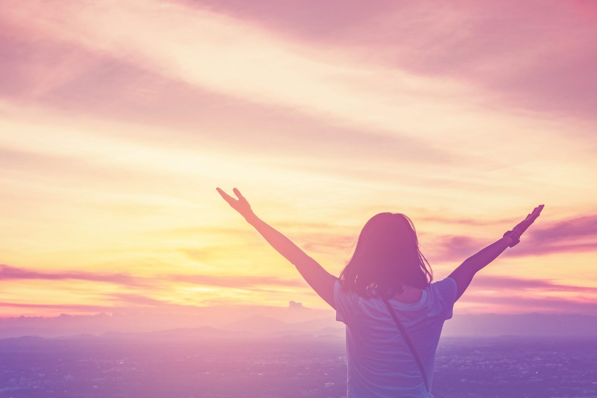 Girl with hands opened to  embrace the sky