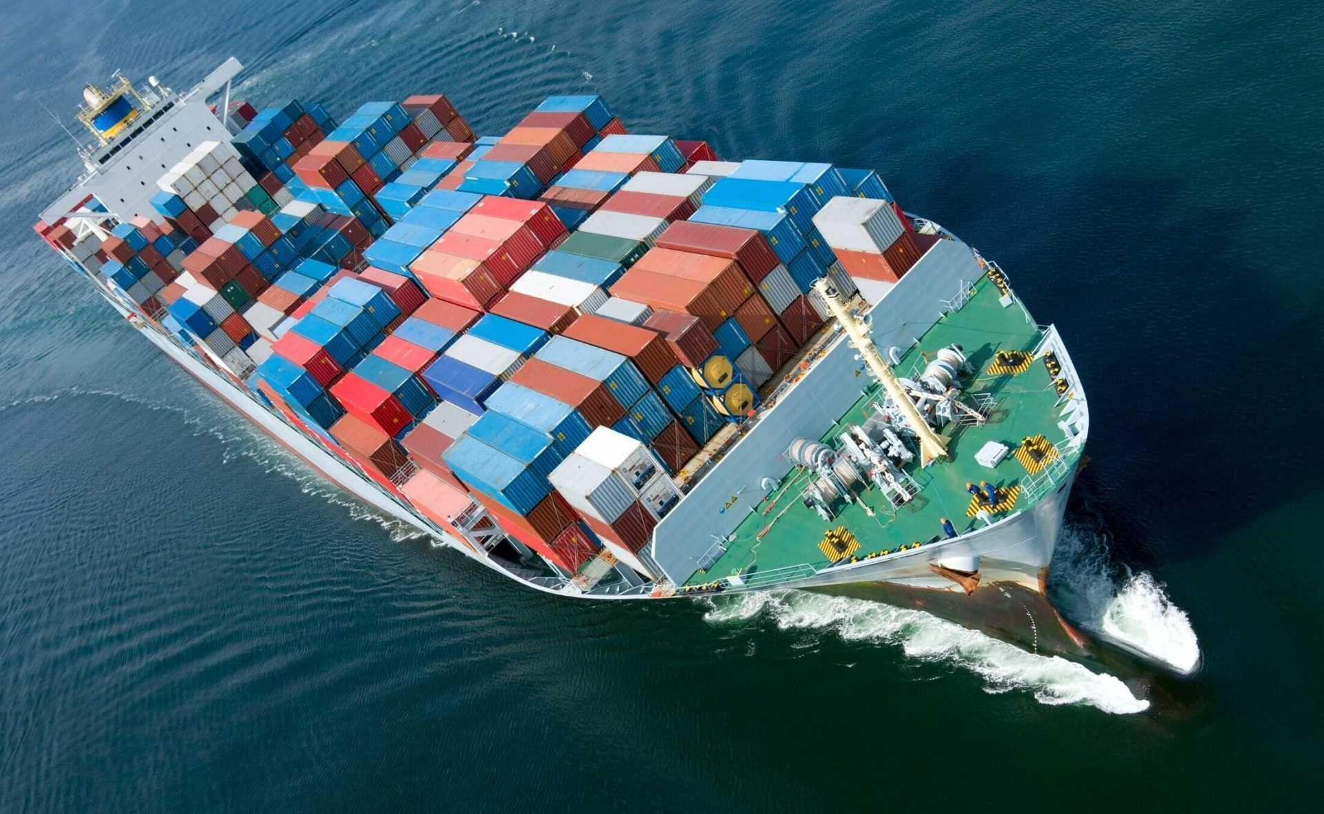 Un gran barco portacontenedores flota sobre un cuerpo de agua.
