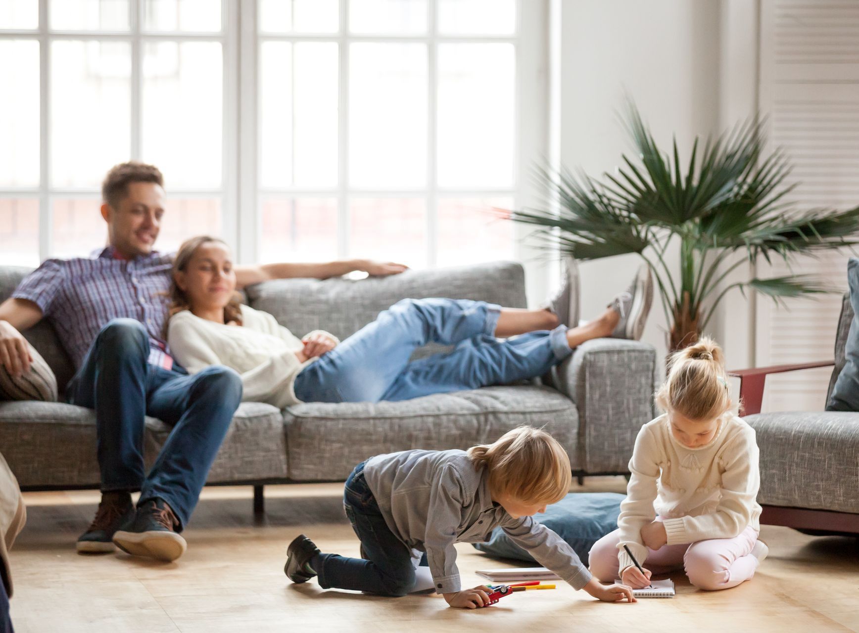 A family is sitting on a couch in a living room.