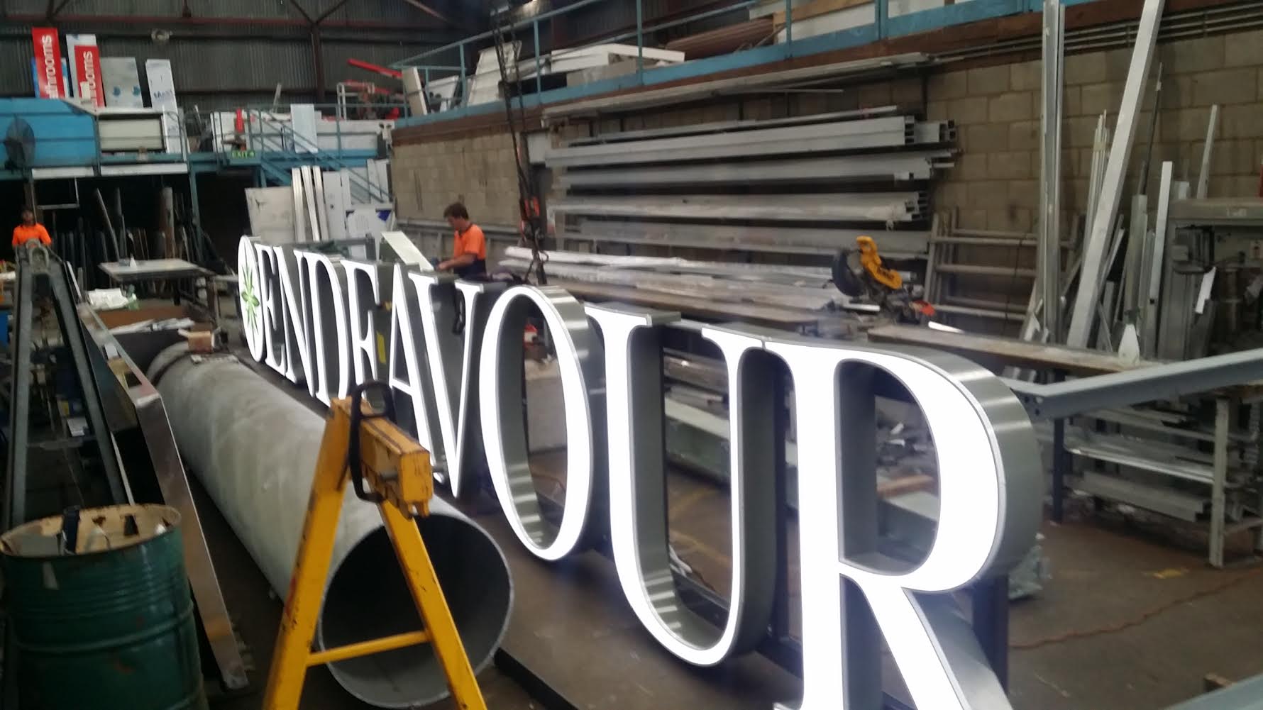 A large sign is being built in a factory.