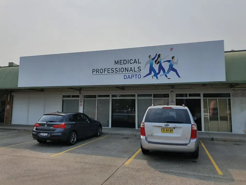 Two cars are parked in front of a building that says medical professionals