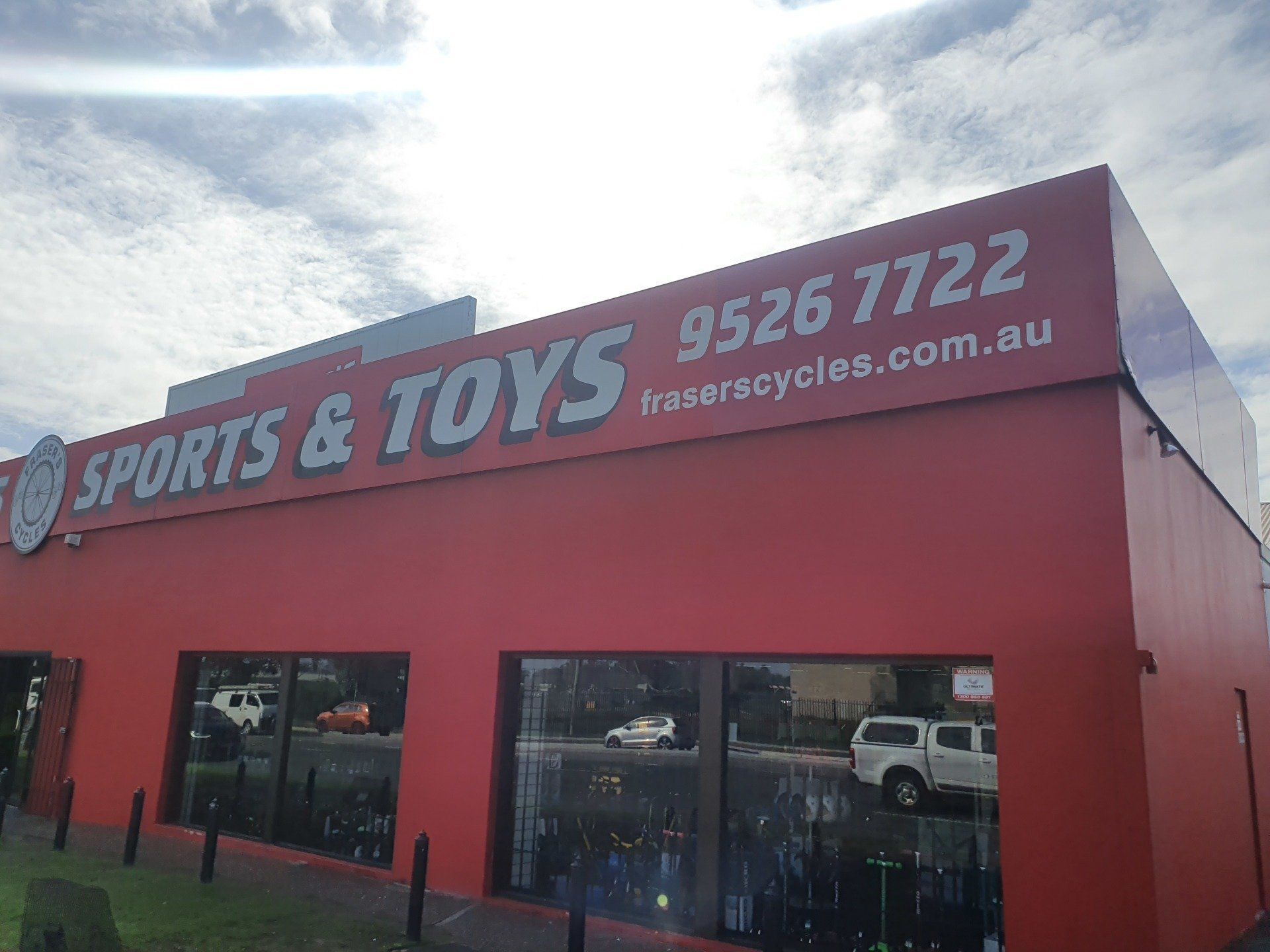 A red building with a sign that says sports and toys