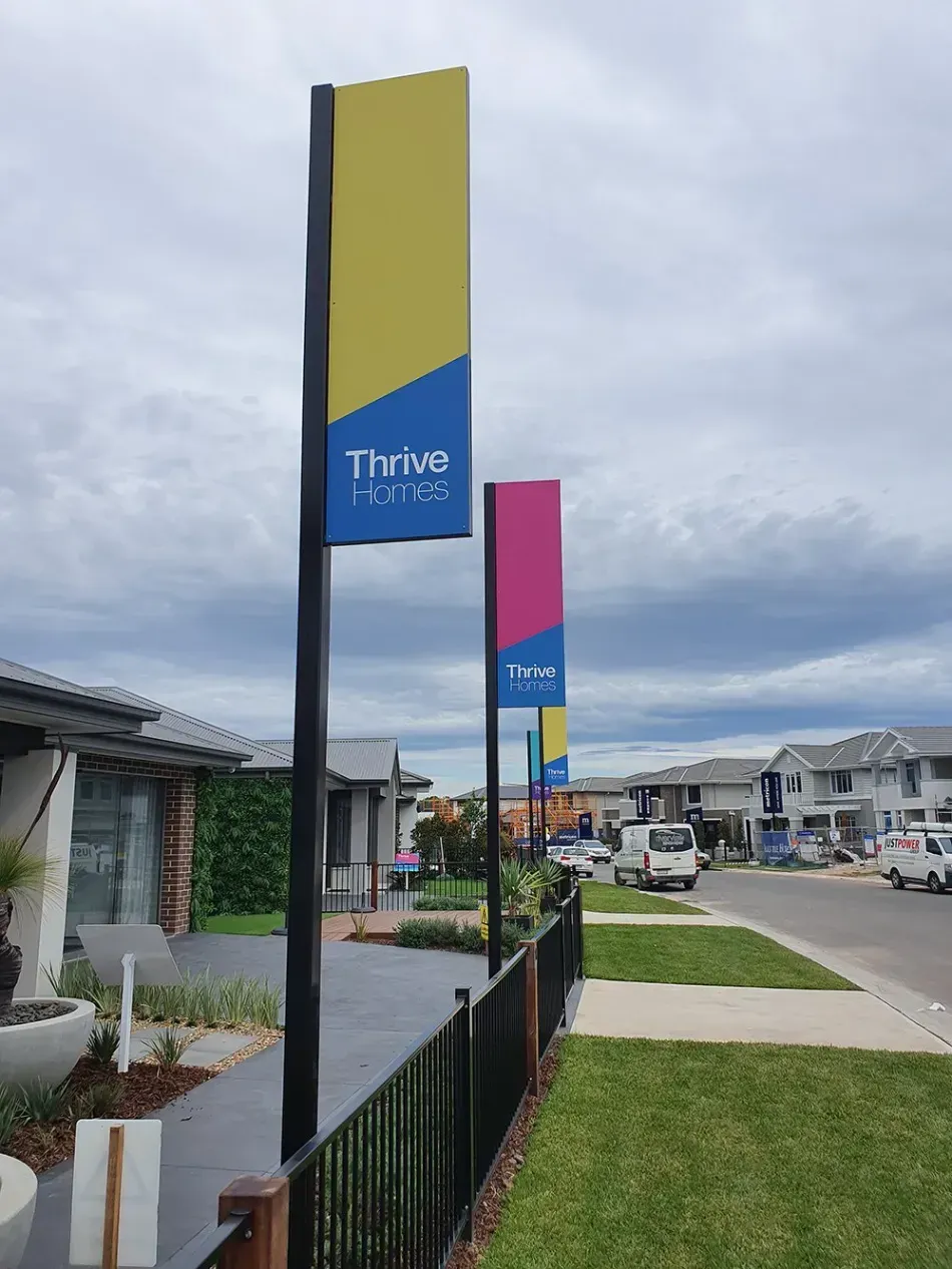 A sign that says thrive homes is on a pole in front of a house.