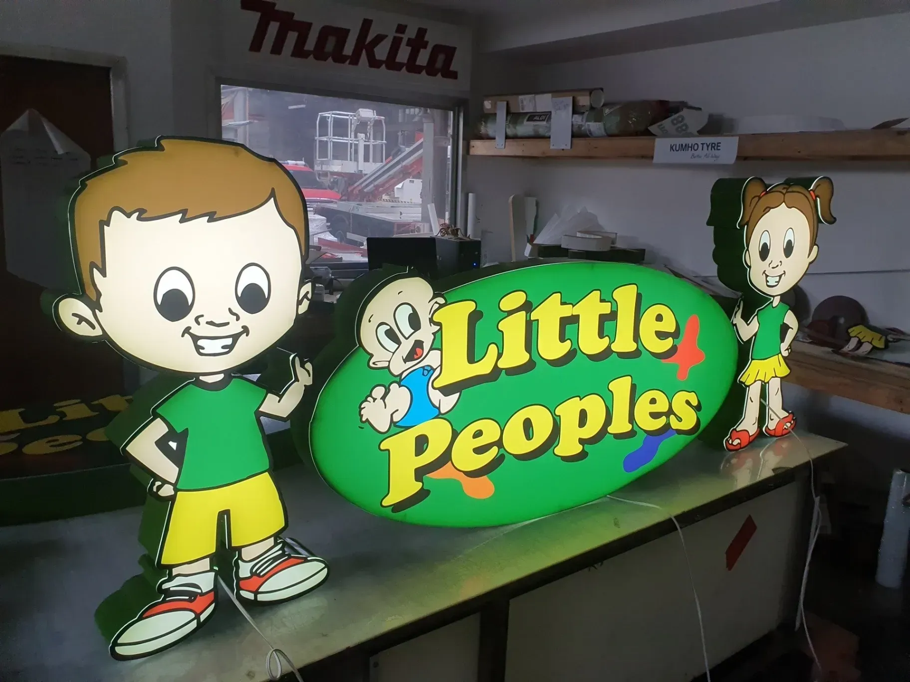 A green sign that says little peoples on it