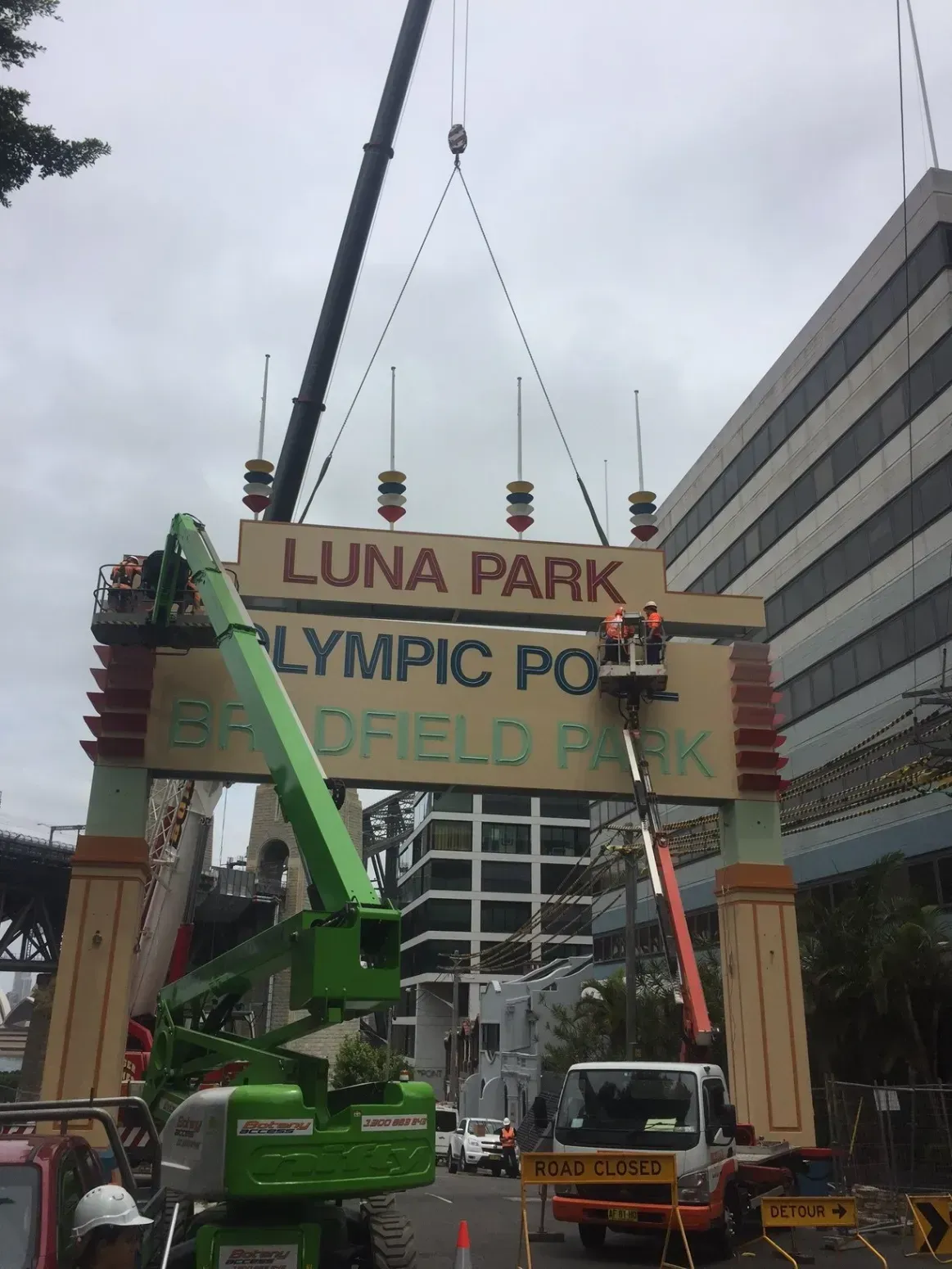 A sign for luna park is being lifted by a crane