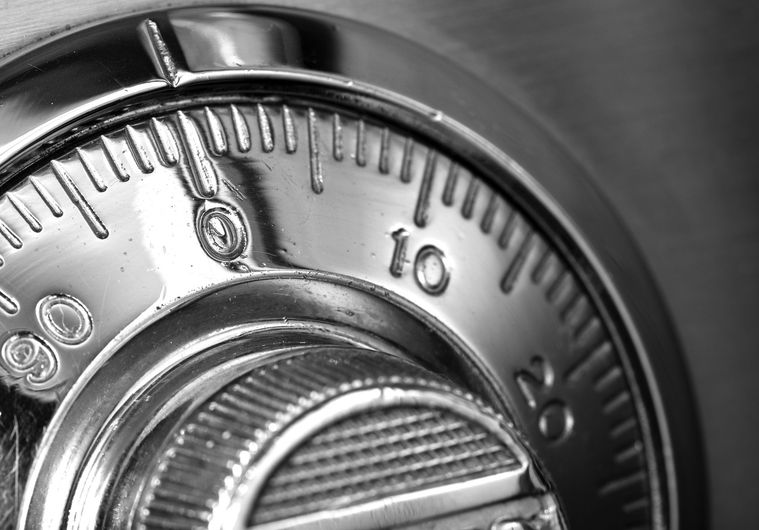 A close up of a combination lock on a safe.