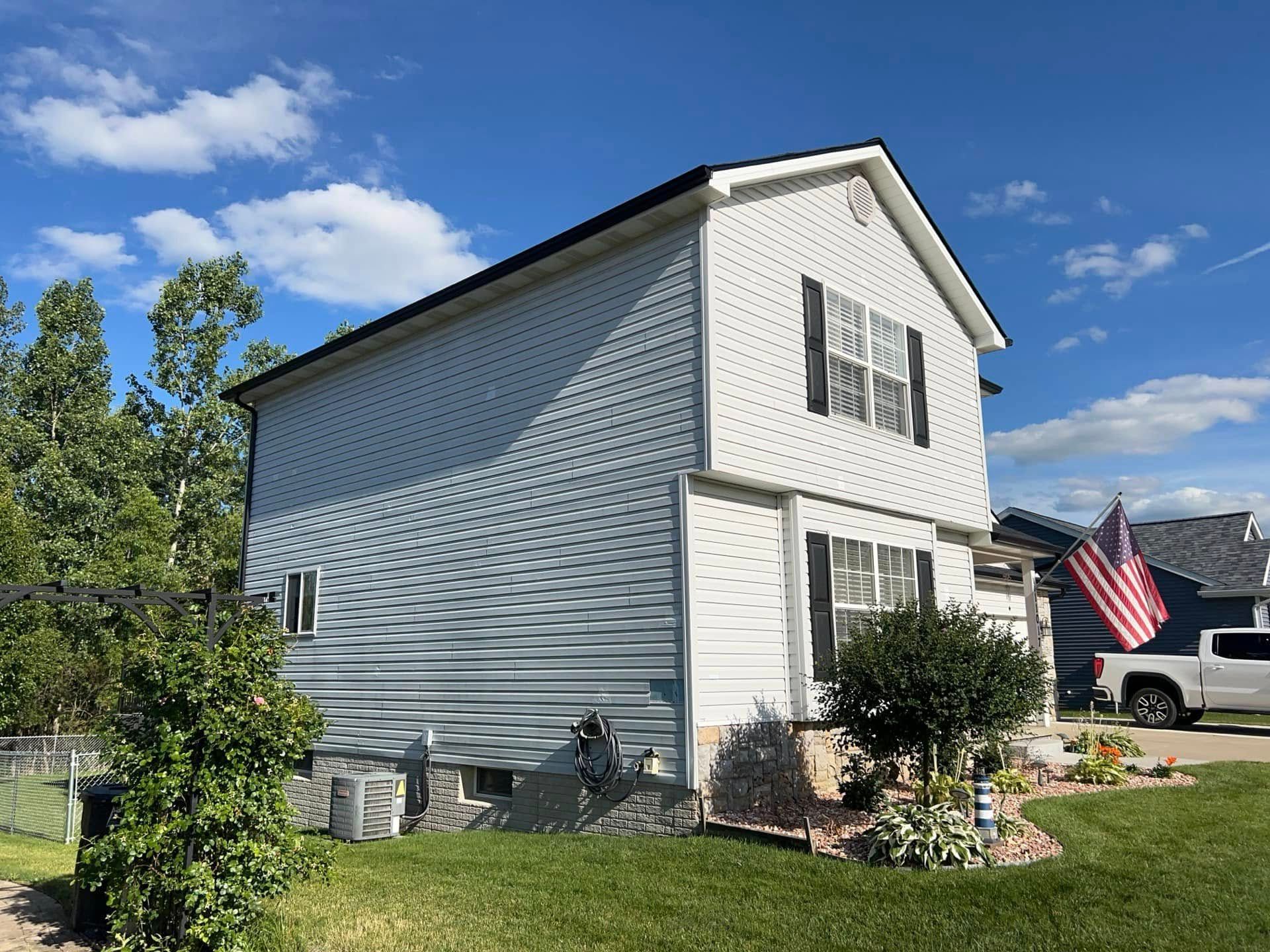 A white house with a truck parked in front of it.