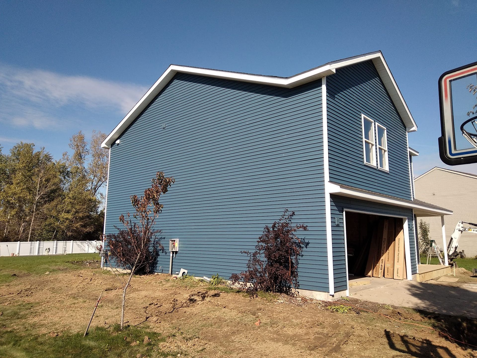 A blue house with a garage underneath it