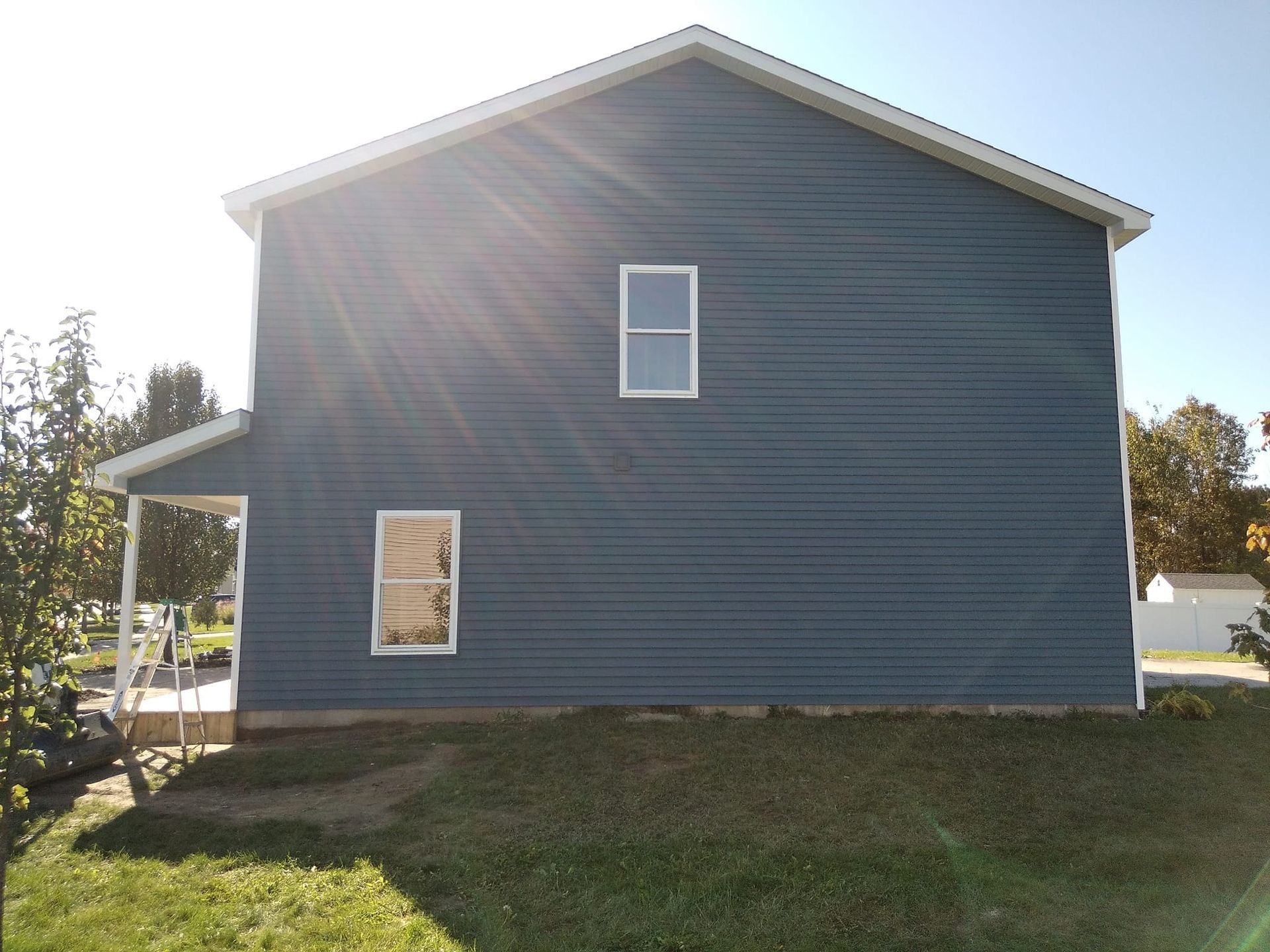 A blue house with a white roof and a porch
