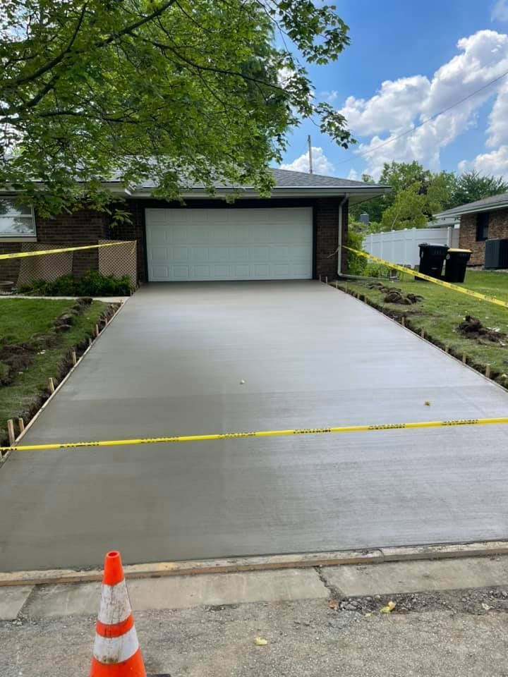 Person applying sealant to a patio made of various colored square tiles.