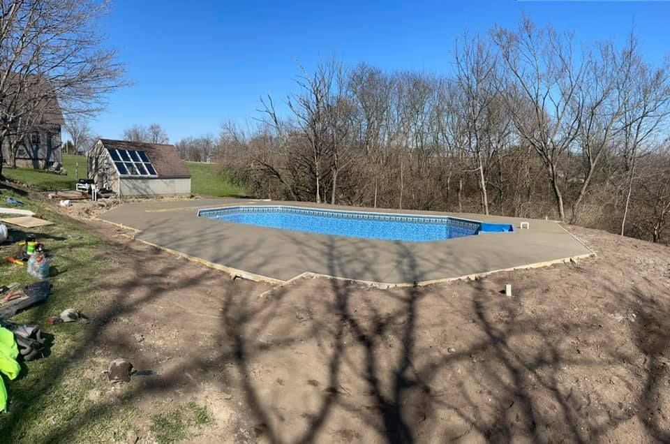 Concrete walkway curves through a landscaped yard, lined with purple flowers and shrubs.
