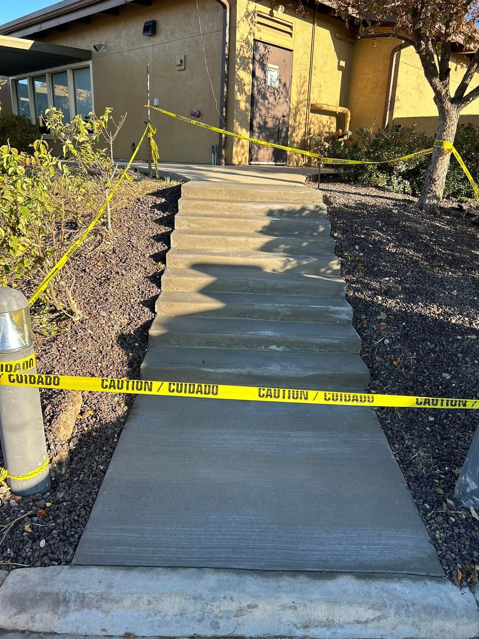 Brick building corner with gravel area bordered by dirt and grass.