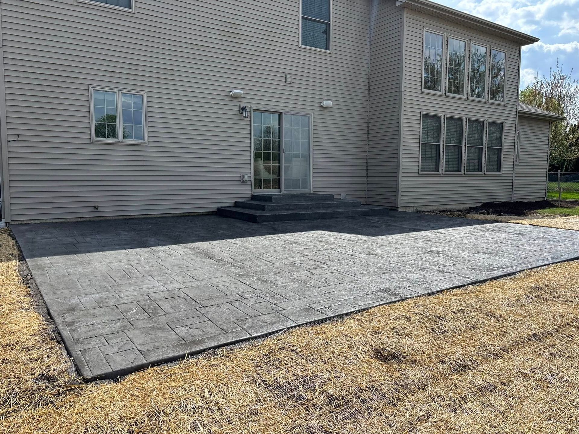 Freshly poured concrete driveway with expansion joints, outdoor setting.