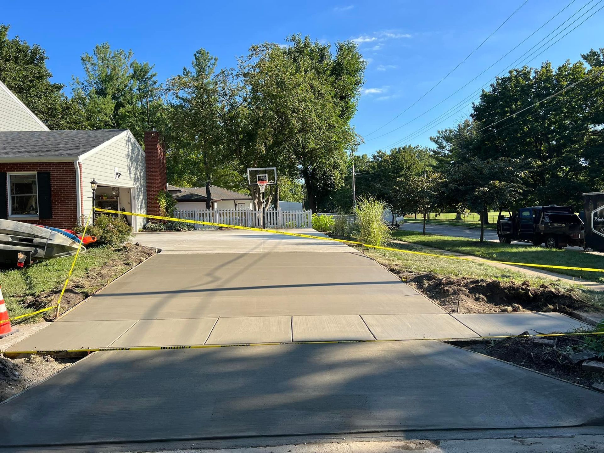 Construction of a swimming pool; worker installing tiles, brown pool walls, white coping with blue trim.