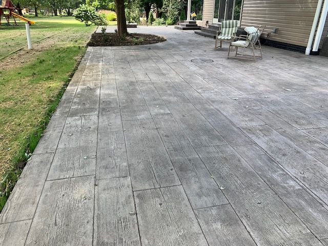 Gray epoxy-coated porch floor with flecks of color; in front of a house.