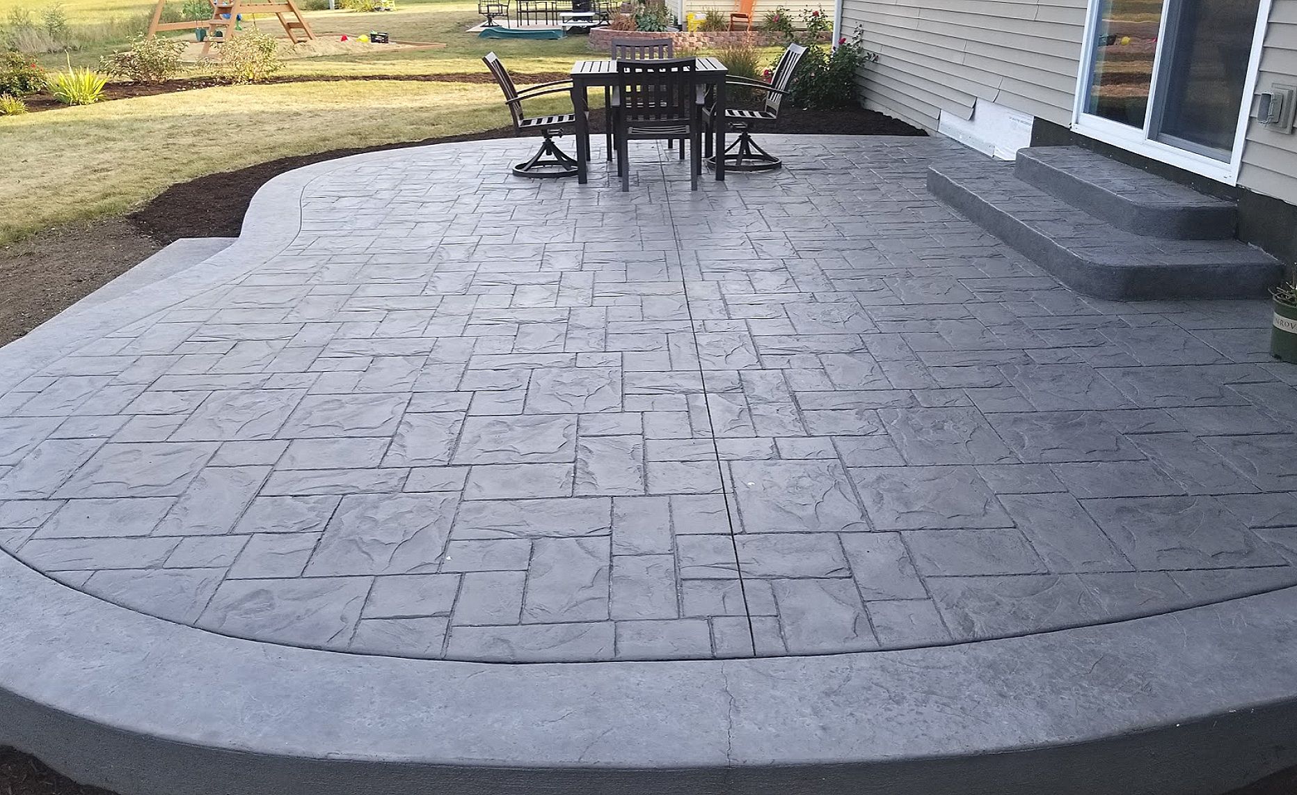 Patio with brick pavers, fire pit, and swimming pool.