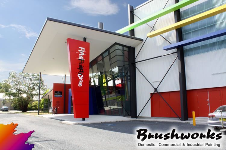 Print Project Plaza building entrance with red sign, colorful accents, and