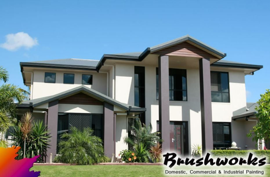 A Man is Installing a Light Fixture on a Wall — Brushworks Painting In North Albury, NSW.