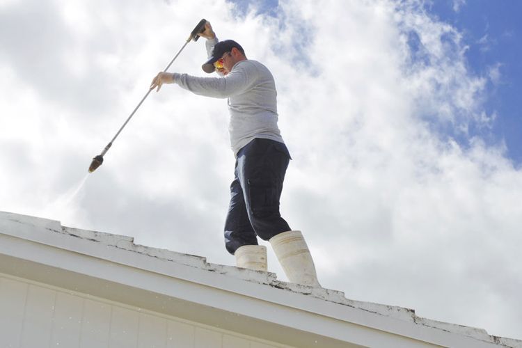 A Man is Painting a Window With a Brush — Brushworks Painting In Thurgoona, NSW.