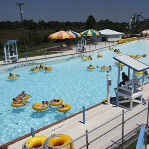 A swimming pool with a lifeguard tower and people in tubes