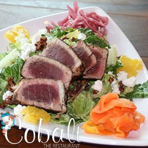 A white plate topped with a salad of meat and vegetables.