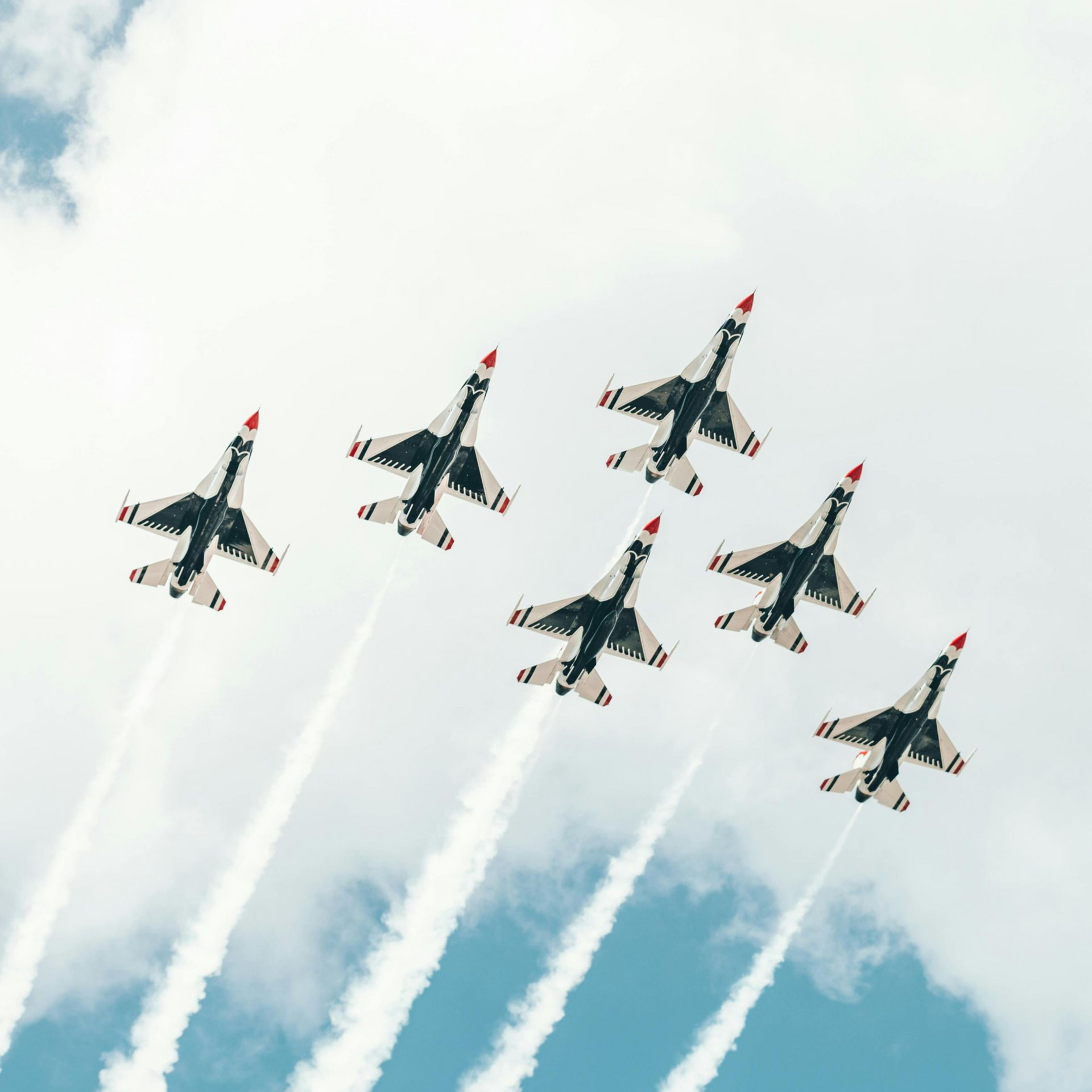 A group of fighter jets are flying in formation in the sky.