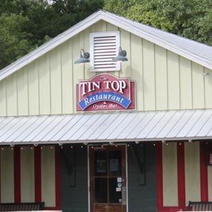A tin top restaurant with a red sign on the front