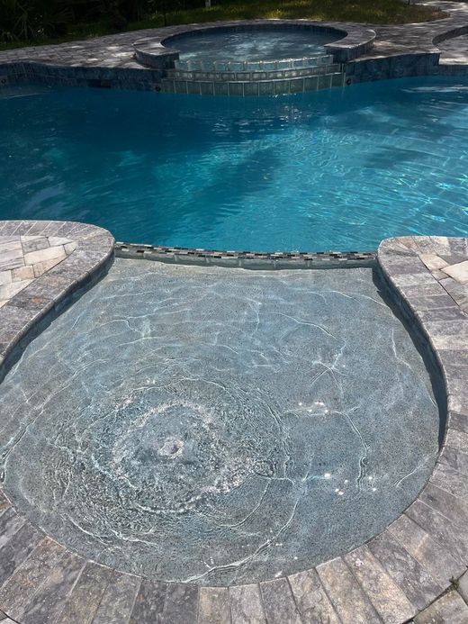 Pool with spa, blue water, stone coping.