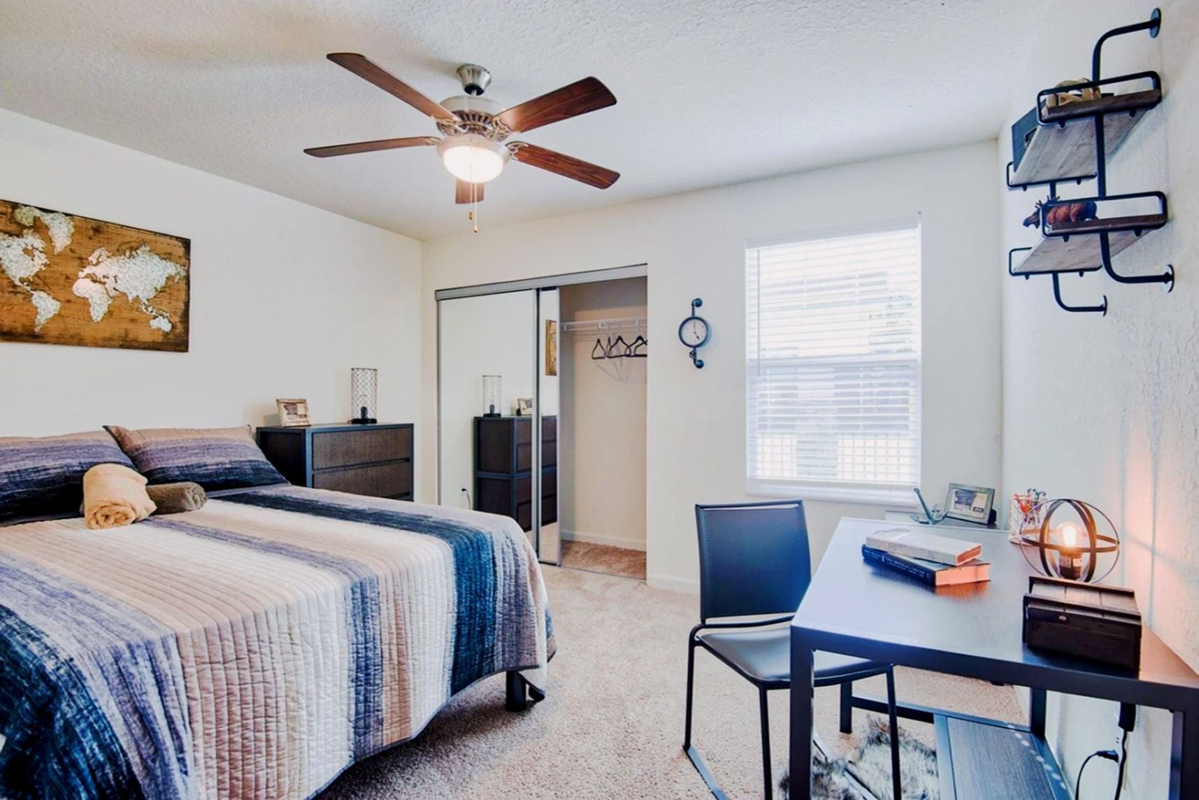Furnished bedroom with bed, desk, shelving, and ceiling fan at Waypoint at Hammond.