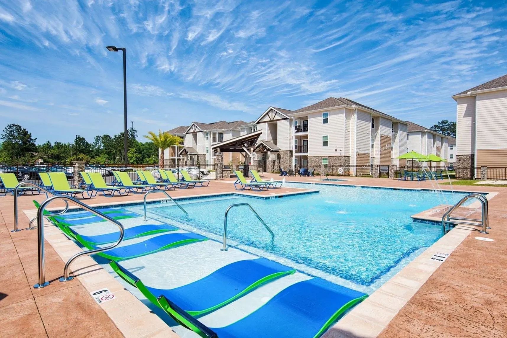 Resort-style pool at Waypoint at Hammond with lounge chairs and clear blue sky.