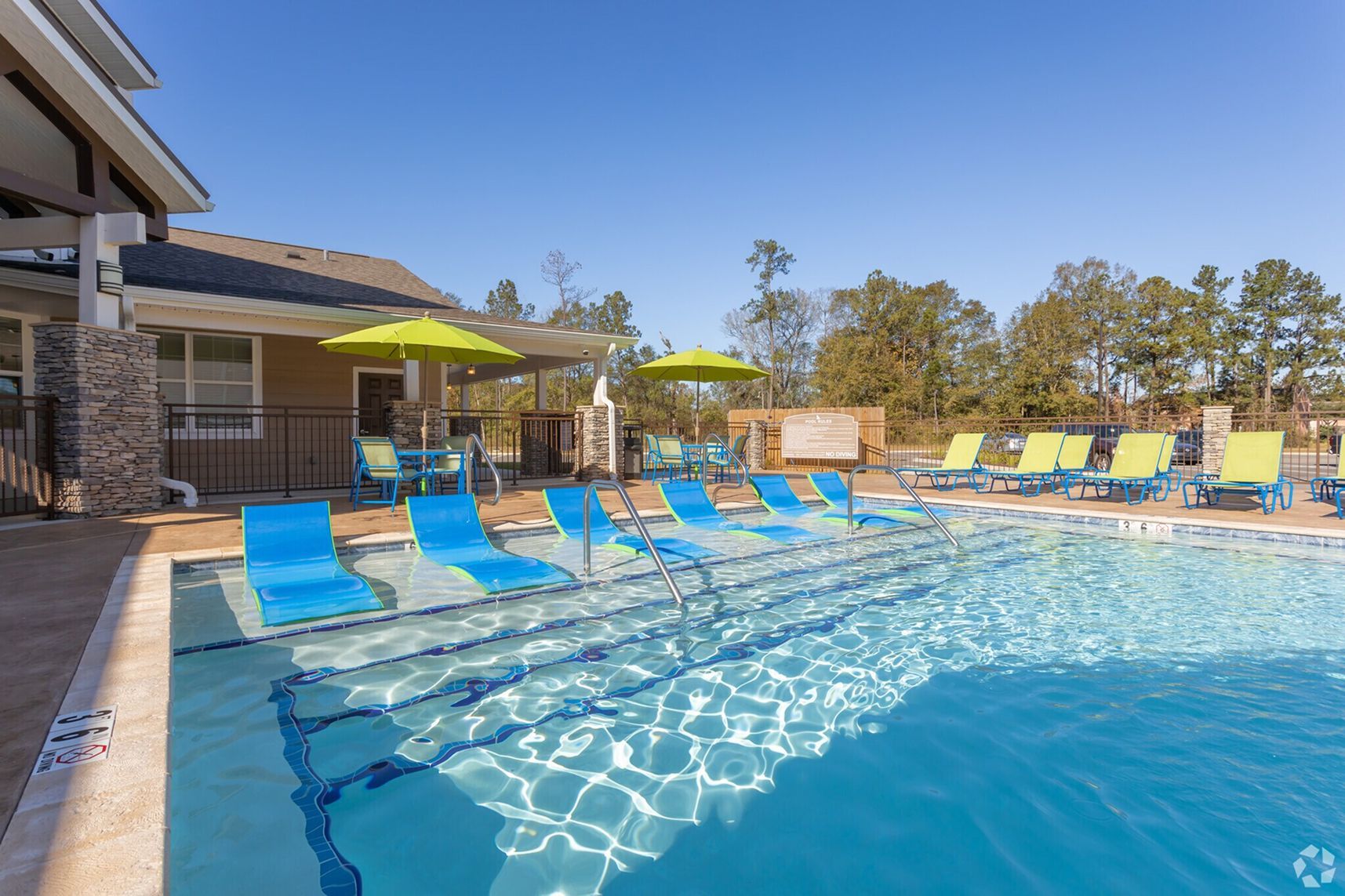 Pool area with shaded seating and modern amenities at Waypoint at Hammond.