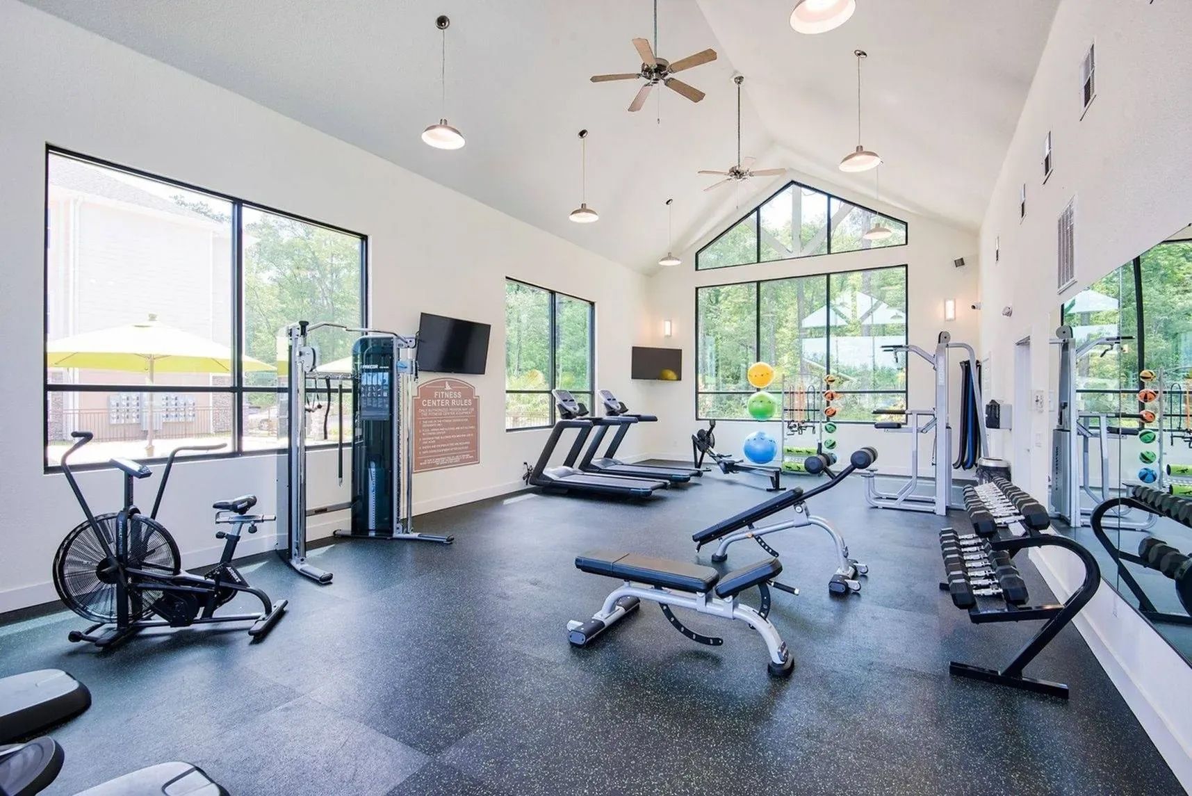 Fitness center with cardio machines, strength equipment, and natural light at Waypoint at Hammond.