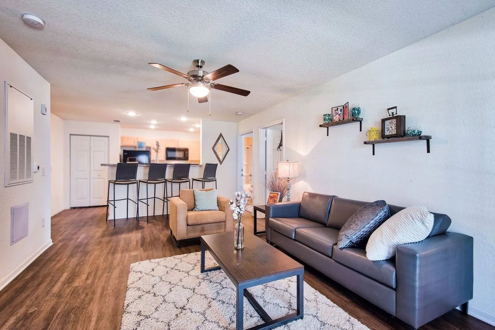 Modern living room with sectional sofa, bar seating, and open layout at Waypoint at Hammond.