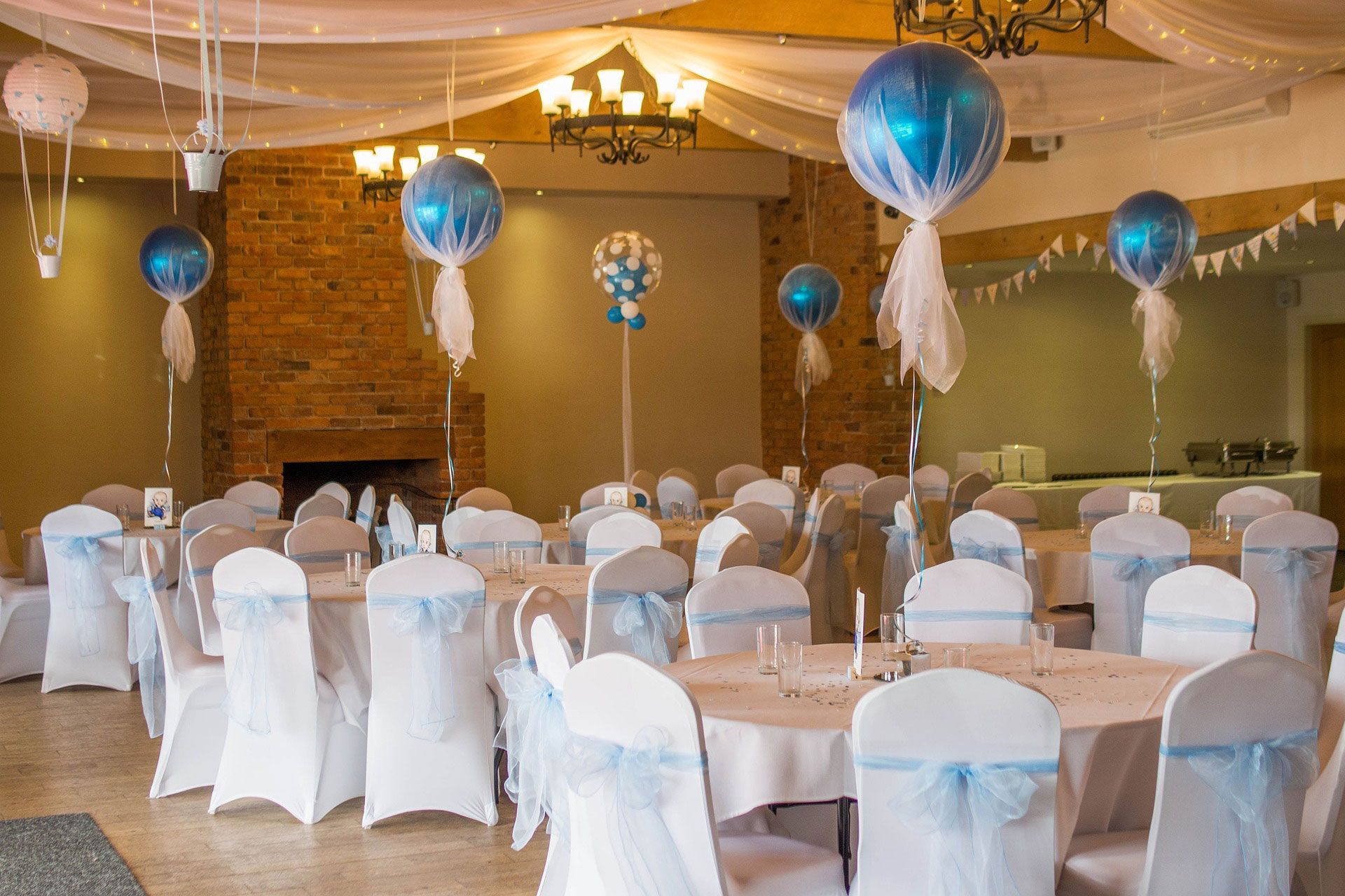 indoor event with tables and chairs and balloons