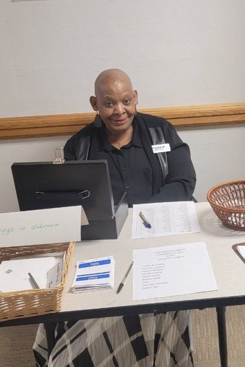 A man is sitting at a table with a computer on it.