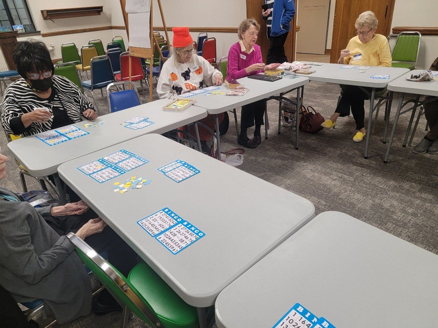 A group of people are sitting at tables playing bingo.
