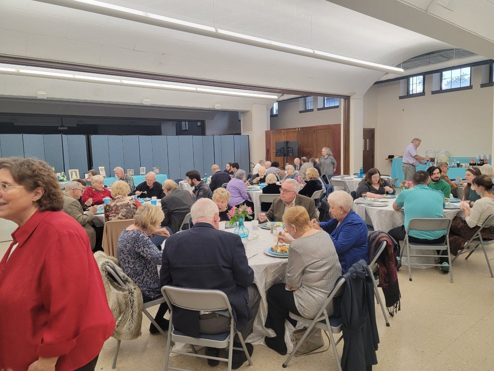 A large group of people are sitting at tables in a large room.
