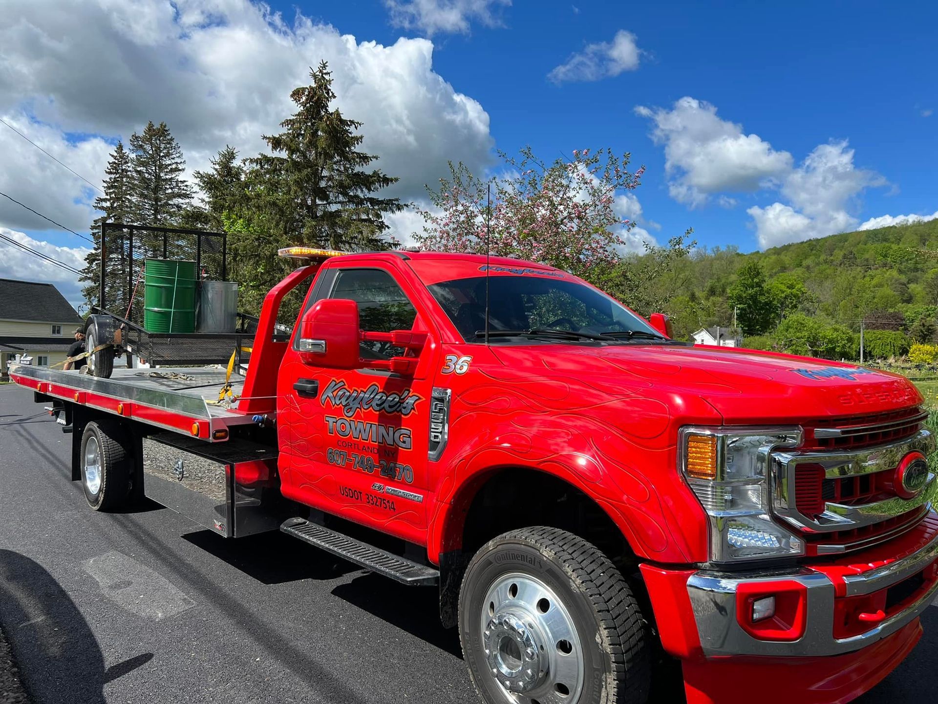 A red tow truck is parked on the side of the road.