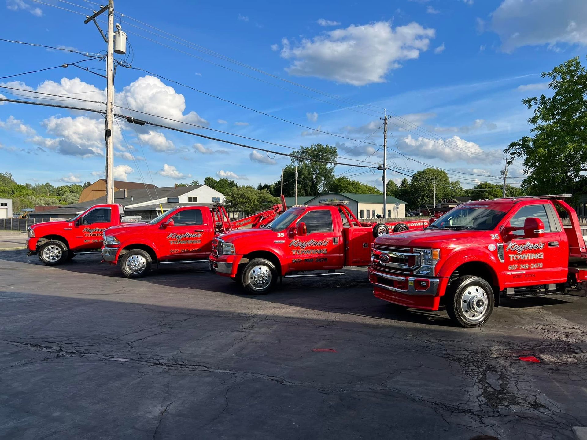 A row of red trucks are parked in a parking lot.