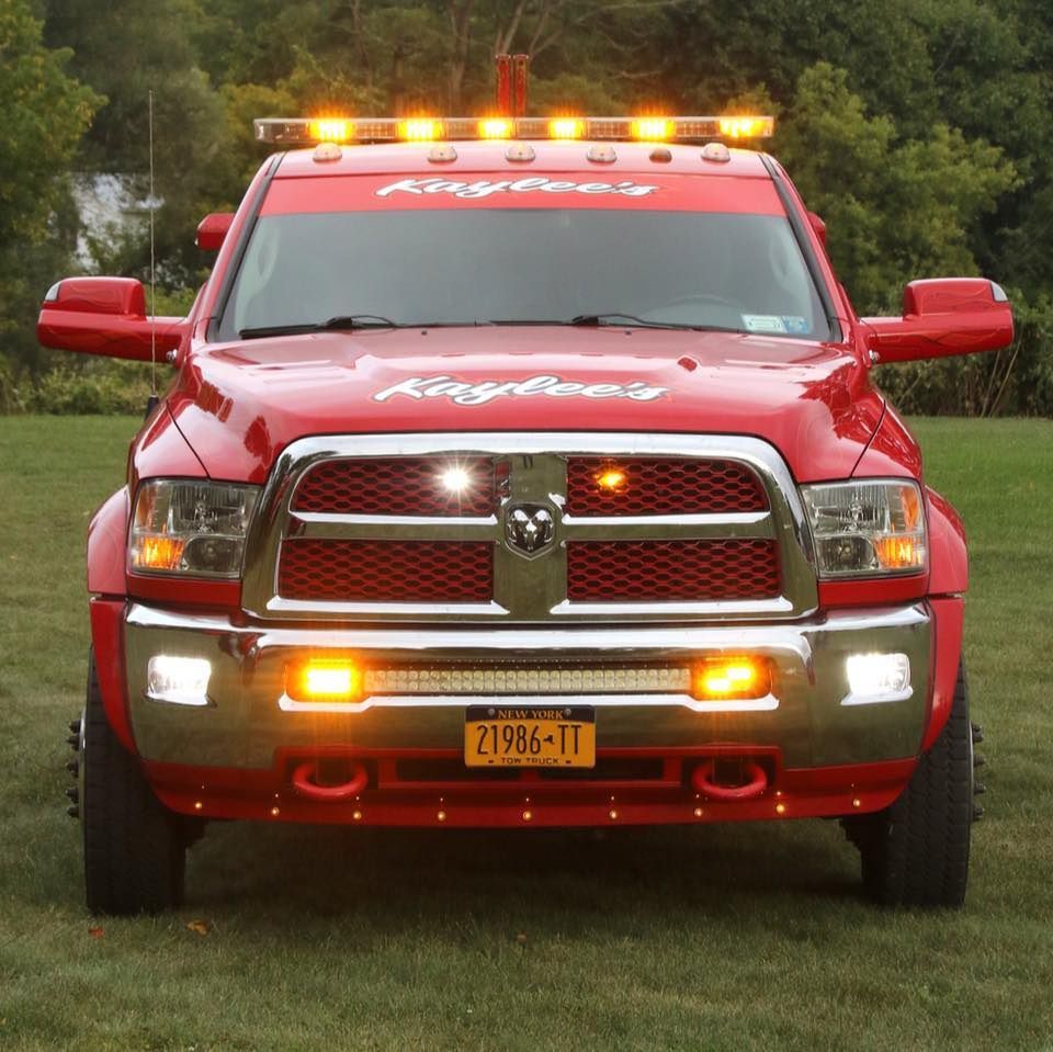 A red kingberry truck is parked in a grassy field