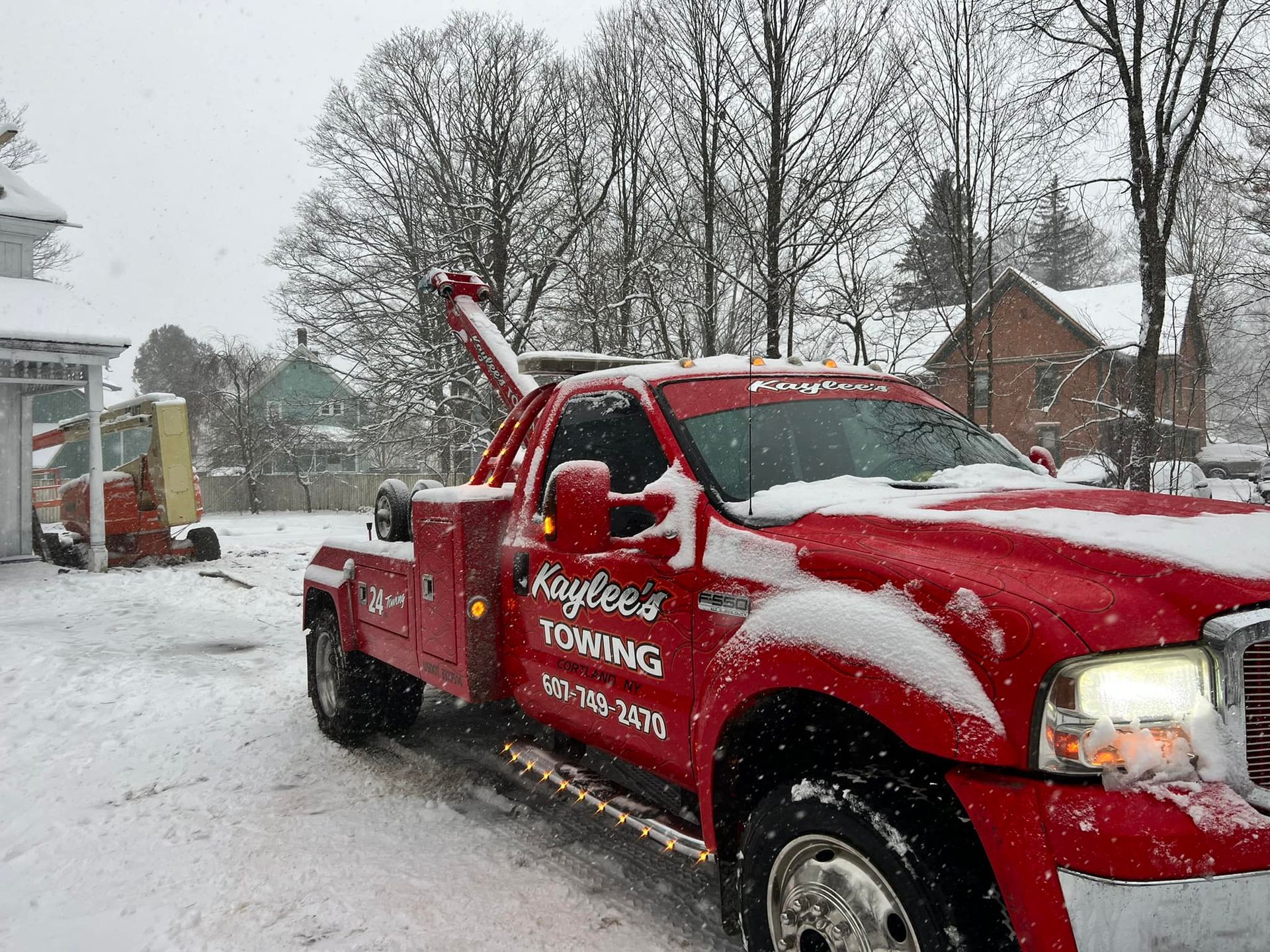 A red tow truck is parked in the snow.