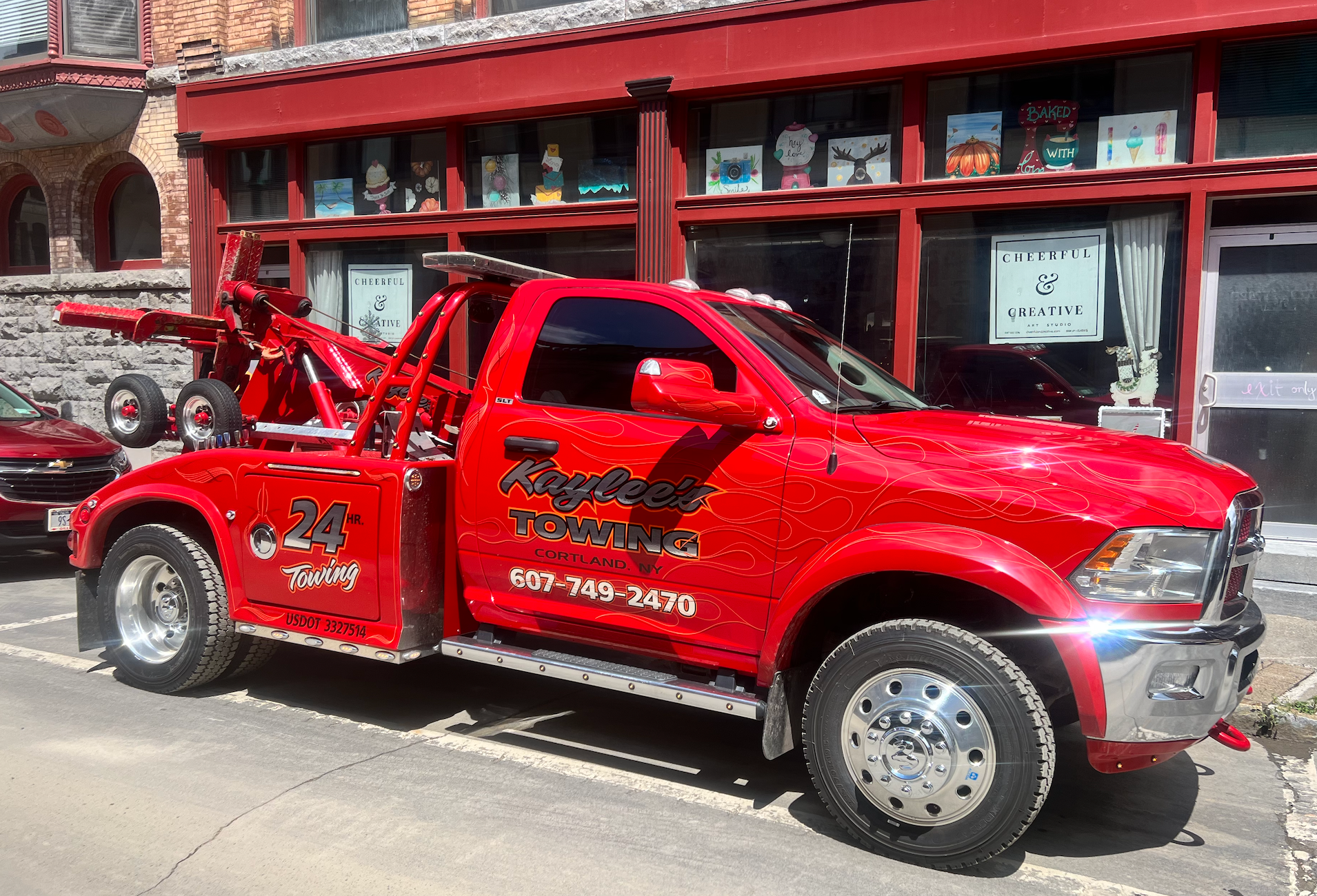 A red tow truck is parked in front of a building.