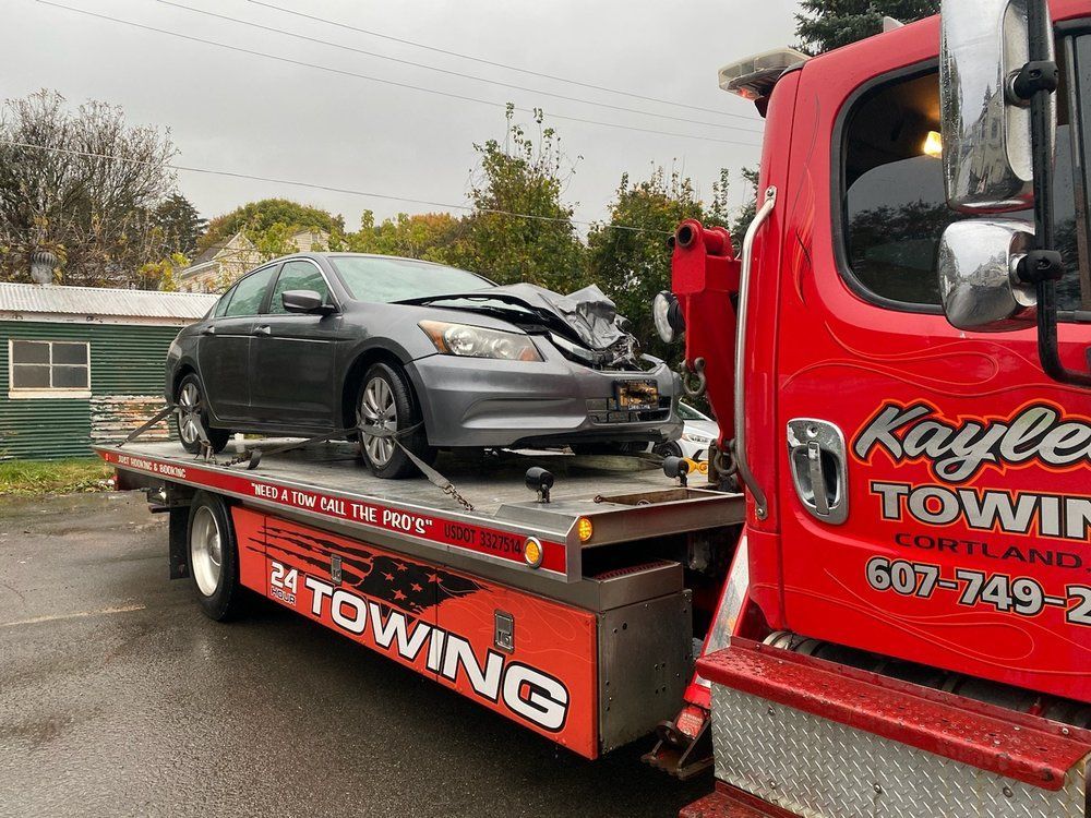 A car is being towed by a red towing truck.