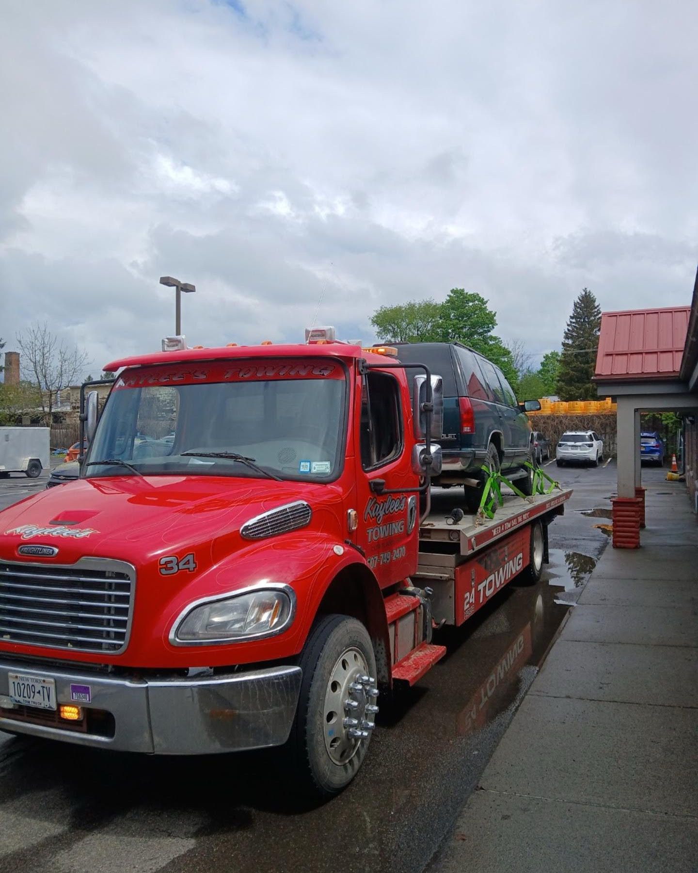A red tow truck is parked on the side of the road