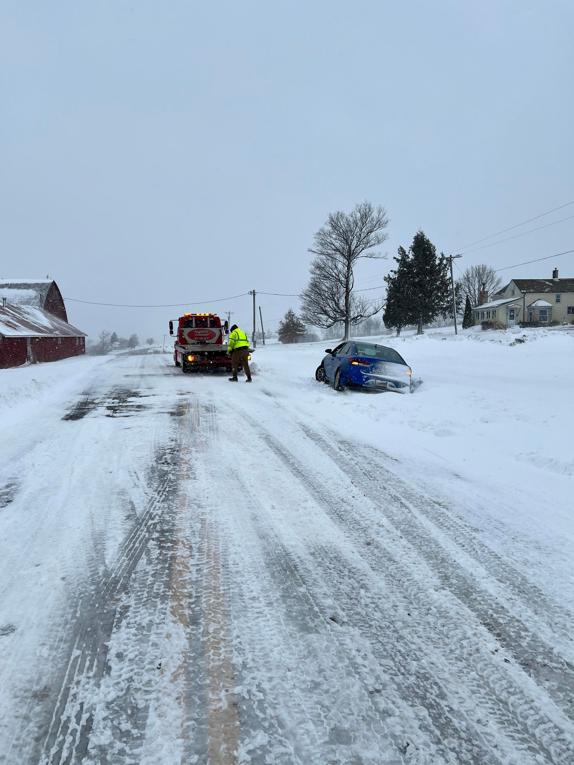 A car is stuck in the snow on the side of the road.