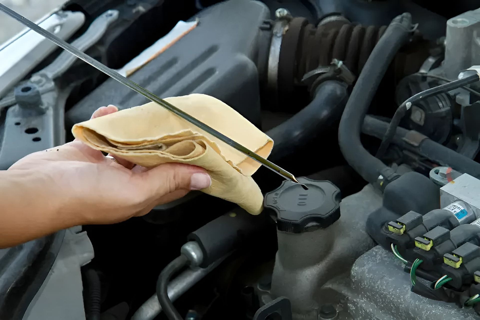 A Person Is Checking The Oil Level Of A Car — C J Mechanical In Berry, NSW