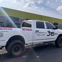 A white truck is parked in front of a building.