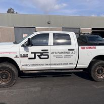 A white truck is parked in front of a building.
