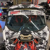 A can am maverick x3 is parked in a garage.