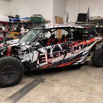 A black and red atv is parked in a garage.
